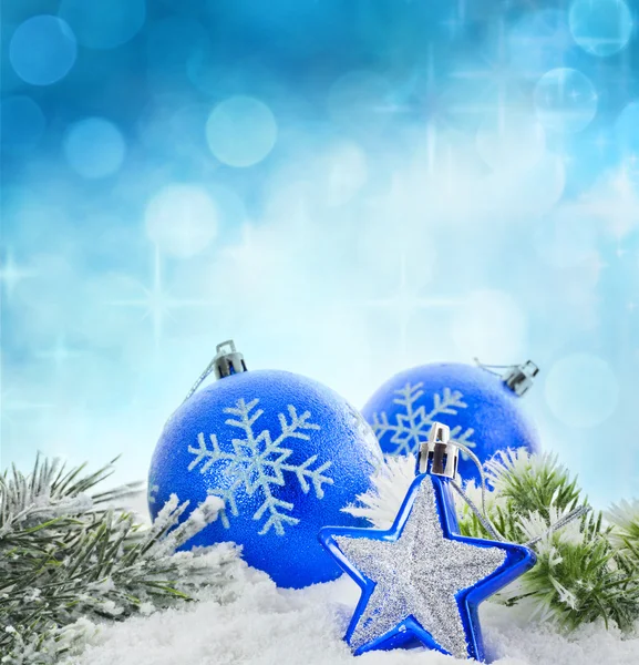 Christmas branch of tree blue baubles and snow background — Stock Photo, Image