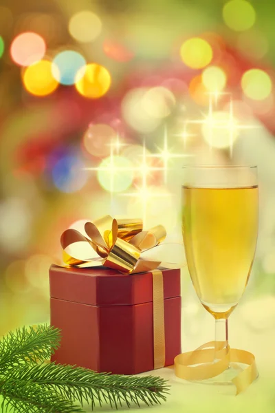 Christmas gift and champagne on the gold background — Stock Photo, Image