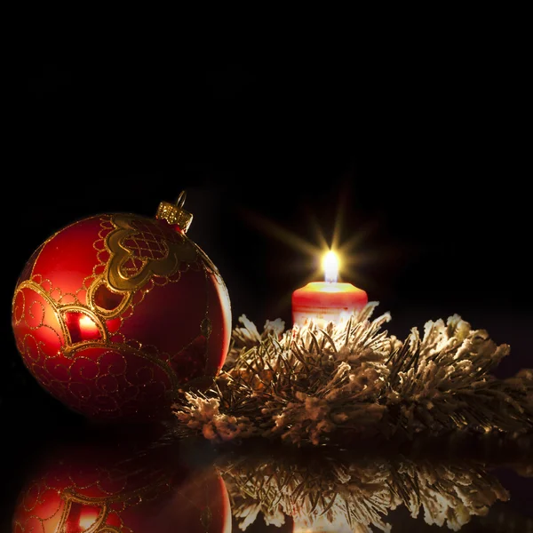 Red christmas bauble with candle in the evening — Stock Photo, Image