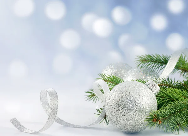 Weihnachtszweig aus Baumband und Christbaumkugel gegen Schnee — Stockfoto
