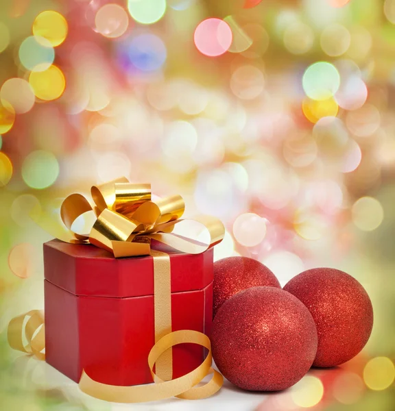Christmas red gift and baubles on colorful background — Stock Photo, Image