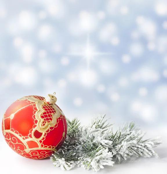 Christmas branch of tree ribbon and bauble against snow — Stock Photo, Image