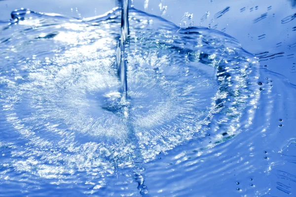 Salpicos de água derramando fundo abstrato azul — Fotografia de Stock