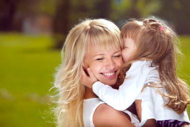 Mother holds her daughter in her arms clipart