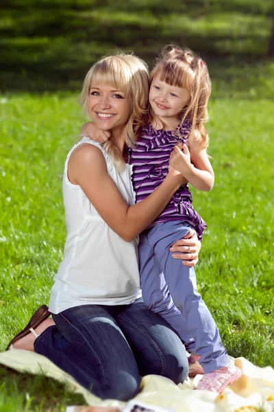 Beautiful young mother hugs her daughter — Stock Photo, Image