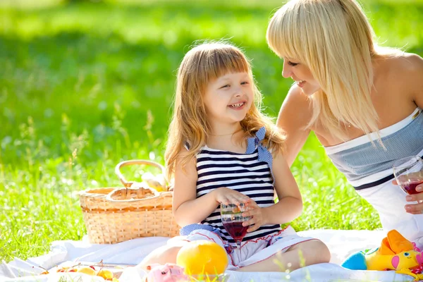 Gelukkig moeder en dochtertje op een picknick — Stockfoto