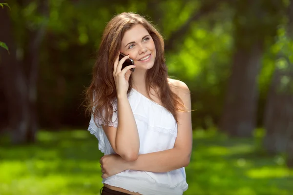 屋外の電話で話している美しい少女 — ストック写真