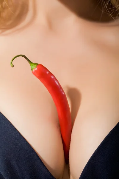 stock image Red hot chili pepper between woman's breasts in black bra