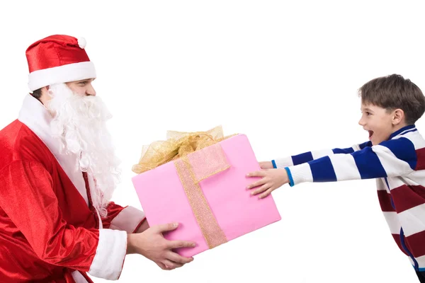 Alegre niño tomando gran regalo de las manos de Santa Claus —  Fotos de Stock