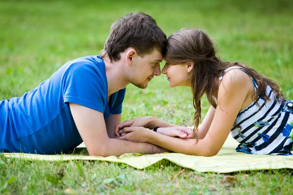 Donna felice e il suo ragazzo riposano sul prato verde nel parco — Foto Stock