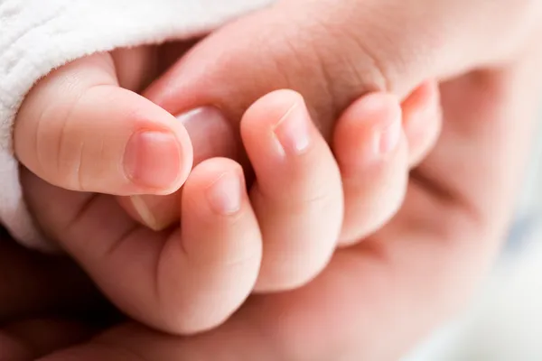Tangan bayi memegang ibu jempol — Stok Foto