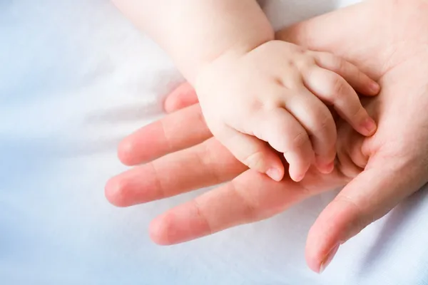 Mães palma com mão bebê recém-nascido em sua superfície — Fotografia de Stock
