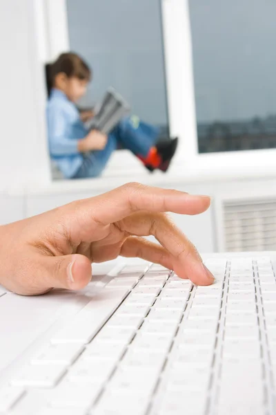Kadın, arka planda bir çocukla klavye düğme üzerinde el — Stok fotoğraf