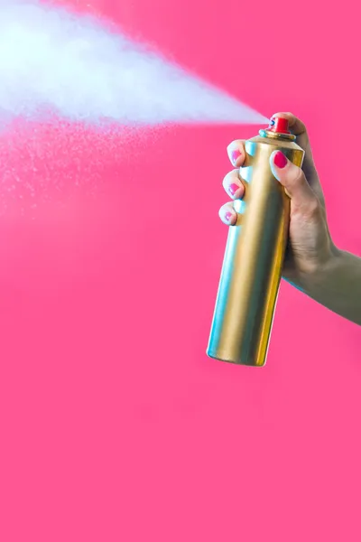 Hair lacquer in female hand spraying it over red background — Stock Photo, Image