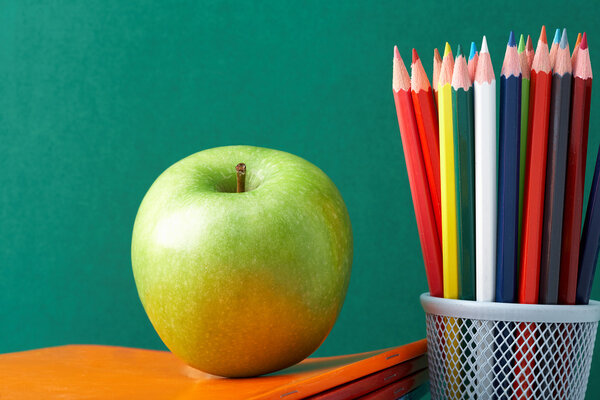 Colorful pencils and apple