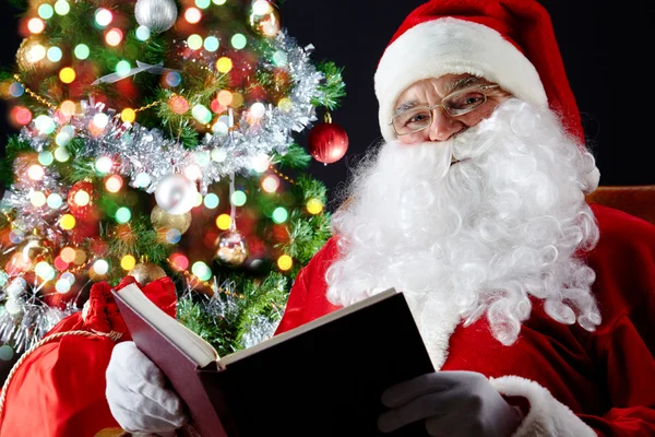 Santa lezen van een boek — Stockfoto