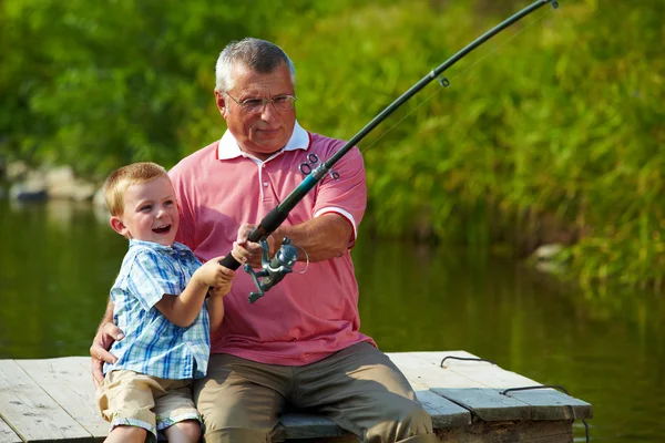 Father and Son Fishing. Dad Shows His Son How To Hold the Spinning