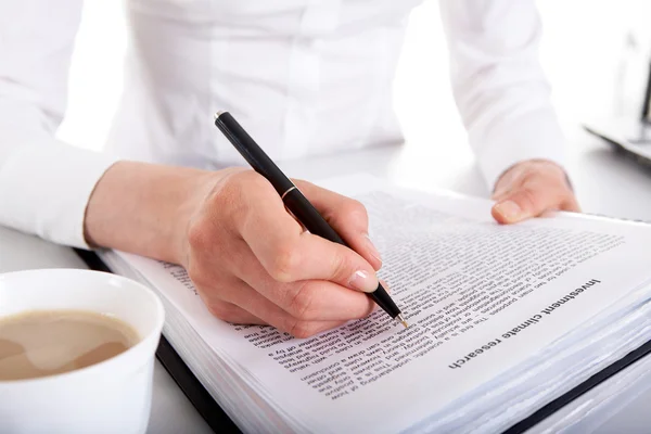 Woman's hand with pen over document — Stock Photo, Image
