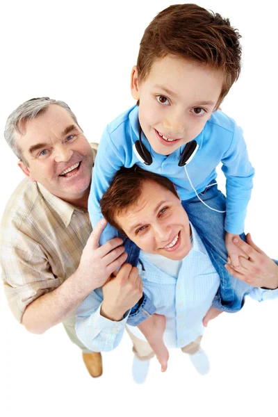 Een jongen zittend op zijn vaders schouders — Stockfoto