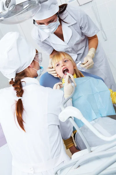 Образ маленької дівчинки, що лікує зуби в кабінеті стоматолога — стокове фото