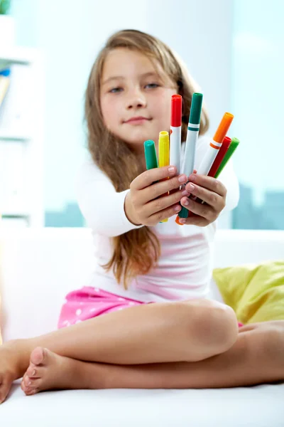 Menina dando lápis de cor — Fotografia de Stock