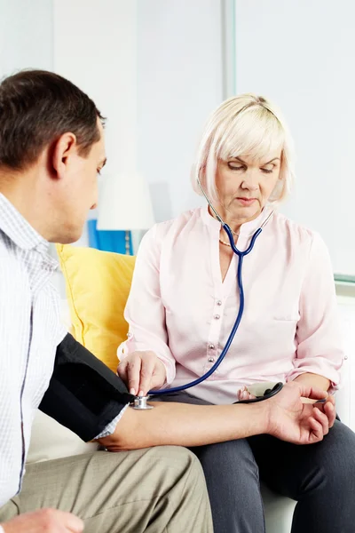 Measuring blood pressure at home — Stock Photo, Image
