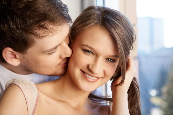 Крупный план молодого человека, целующегося в шею женщине — стоковое фото