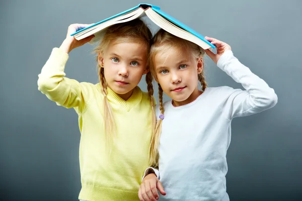 Twins under book — Stock Photo, Image