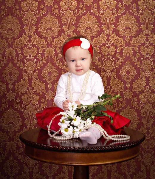Κοριτσάκι σε όμορφο φόρεμα που κάθεται στο τραπέζι — Φωτογραφία Αρχείου