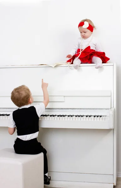Två barn nära piano — Stockfoto