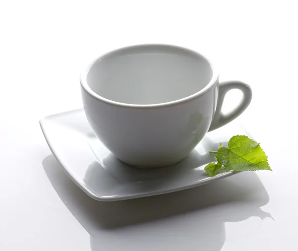 White cup with green leaf — Stock Photo, Image