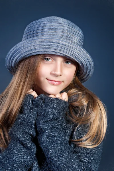 Portret van een jong meisje in blauwe hoed en trui — Stockfoto