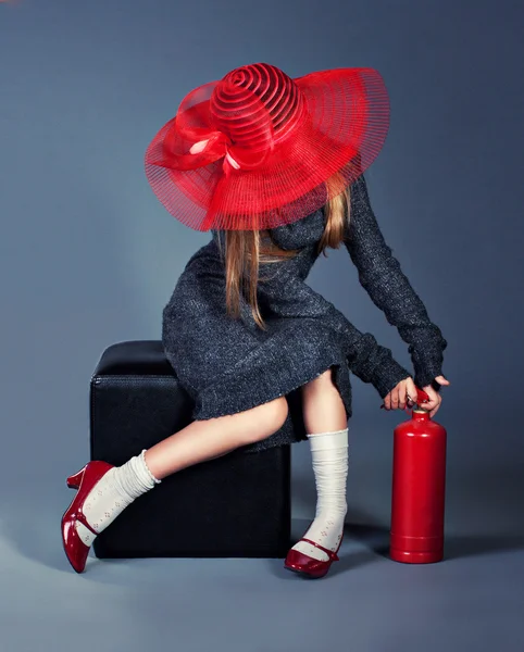 Chica de moda con extintor de incendios en gran sombrero rojo y zapatos rojos — Foto de Stock