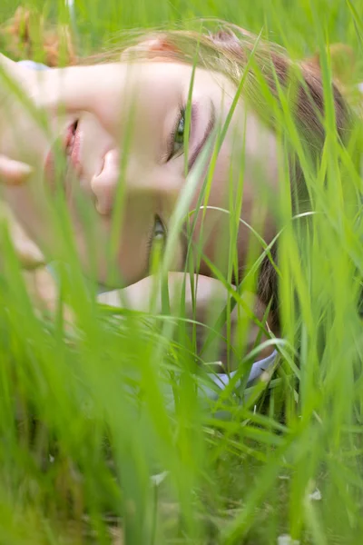Junge Frau liegt im Gras — Stockfoto