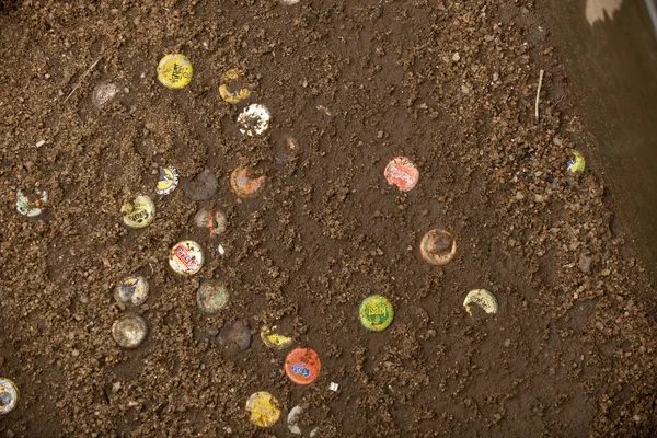 Discarded soda caps in ground, Tanzania, Africa — Stock Photo, Image