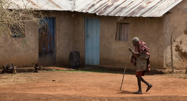 Äldre kvinna gå genom byn, tanzania, Afrika — Stockfoto