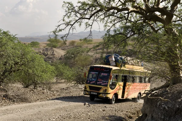 Bus traveling on dirt road, Tanzania, Africa