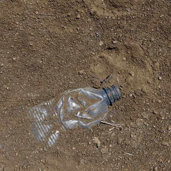 Kasserade plastflaska nära fotavtryck, tanzania, Afrika — Stockfoto