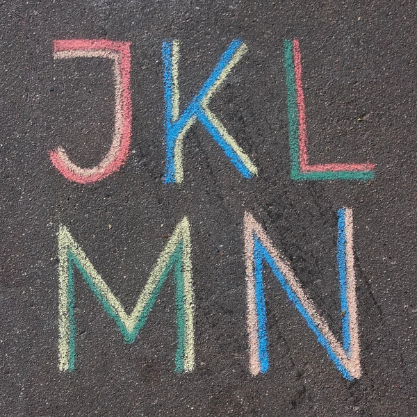 Lettere alfabetiche disegnate su asfalto con gesso, j, k, l, m, n Foto Stock Royalty Free