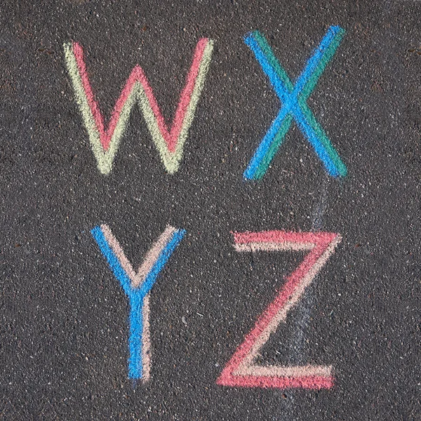 Buchstaben auf Asphalt mit Kreide gezeichnet, w, x, y, z Stockbild