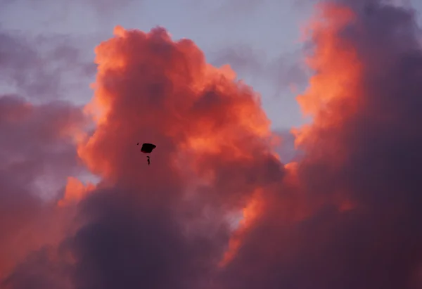 Parapente subindo alto no céu vermelho brilhante — Fotografia de Stock