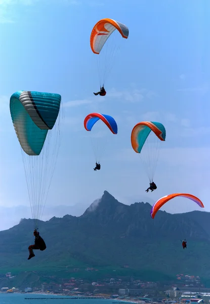 Los parapentes se elevan sobre las montañas Imagen de archivo