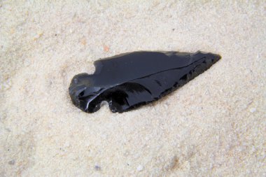 Ancient arrowhead on the beach. clipart