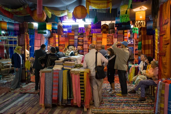 Compradores en tienda de tela de colores en Fez Imágenes de stock libres de derechos