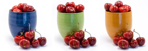 Saftiga ruby röda körsbär i blått, grönt och orange koppar — Stockfoto