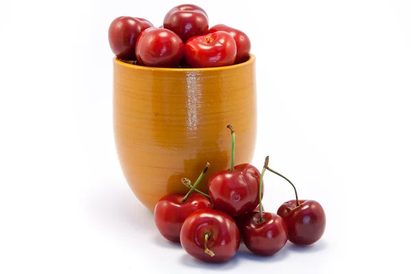 Juicy ruby red cherries in an orange cup — Stock Photo, Image