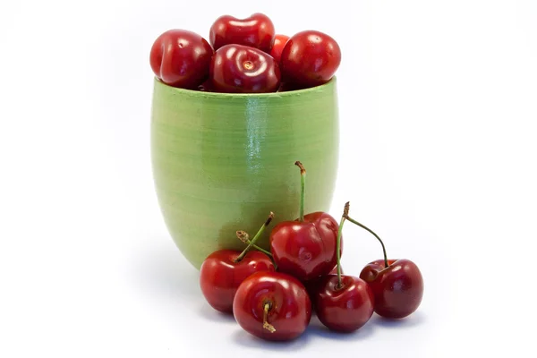 Juicy ruby red cherries in a green cup — Stock Photo, Image