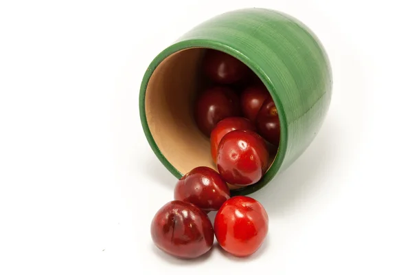 Juicy ruby red cherries in a green cup — Stock Photo, Image