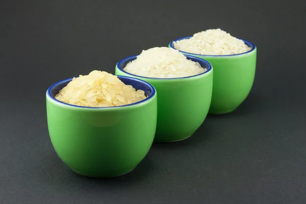 Три сорта риса в трех маленьких зеленых чашках — стоковое фото