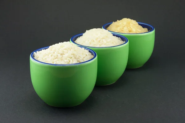 Tres variedades de arroz en tres tazas verdes pequeñas — Foto de Stock